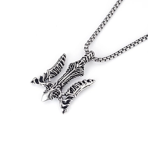 Detailed macro view of a vintage silver trident pendant with an oxidized steel finish