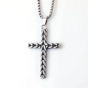 Vintage stainless steel cross necklace with wheat pattern and braided details on white background