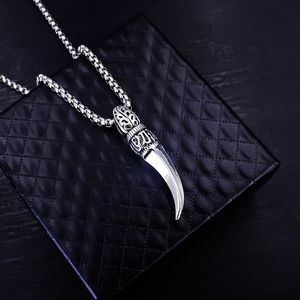 Vintage stainless steel wolf tooth pendant necklace on a black jewelry box case