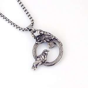 Detailed view of vintage gothic crow pendant with woven ring and silver box chain