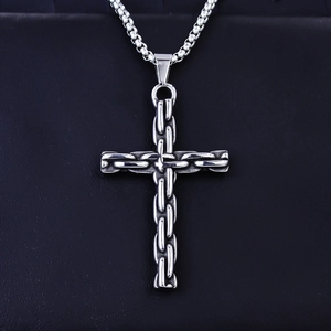 Gros plan d'un pendentif croix vintage en acier inoxydable avec texture tissée sur cuir