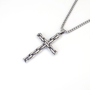 Gros plan détaillé du pendentif croix rétro avec texture tressée sur une chaîne vénitienne