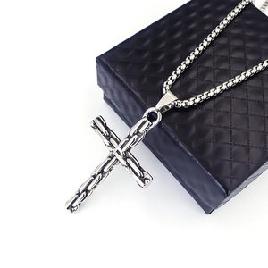 Gros plan détaillé du pendentif croix en acier inoxydable argenté avec chaîne maille box