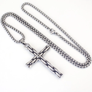 Gros plan du pendentif croix en acier vintage avec texture de chaîne tressée détaillée