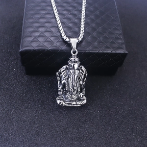 Dettaglio ravvicinato di un ciondolo Ganesha color argento con incisioni fini e catena