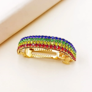 Vue macro détaillée d'une barrette dorée ornée de quatre rangées de strass arc-en-ciel