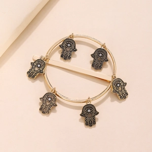 Dettaglio di un fermaglio per capelli vintage dorato con ciondoli Mano di Fatima