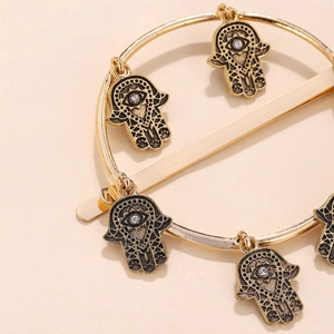 Dettaglio di ciondoli mano di Hamsa dorati con motivi occhio su un fermaglio in metallo
