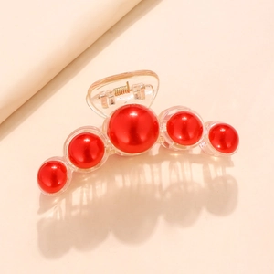 Macro shot of large hair claw clip with five glossy red pearls on transparent resin