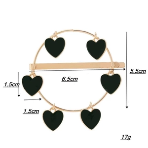 Barrette dorée circulaire avec cœurs noirs et détails de dimensions de 6,5 cm