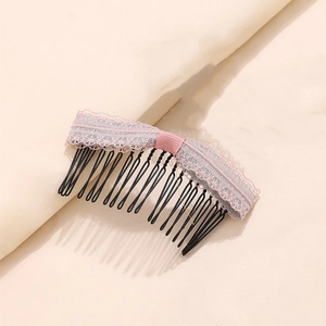 Dettaglio del pettine per capelli in pizzo rosa con denti metallici ondulati