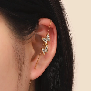 Detail of elegant gold butterfly ear cuff wrap with sparkling rhinestones on model