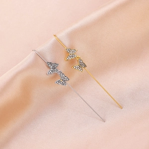 Detail of gold and silver butterfly ear crawlers with micro-set rhinestones
