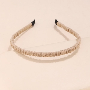 Detail of pleated fabric headband in beige showing smooth texture and protective black ends