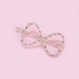 Detailed view of golden bow hair clip featuring shimmering AB colorful rhinestones