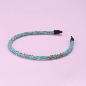 Narrow blue and orange sequined headband for women on light pink background