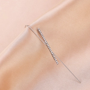 Detail view of silver ear crawler with sparkling round zircons on champagne satin fabric
