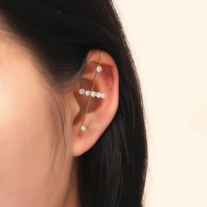 Detailed close-up of a gold lightning leaf ear crawler set with white zircon stones