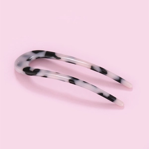 Detail view of U-shaped hair pin in black and white leopard print cellulose acetate