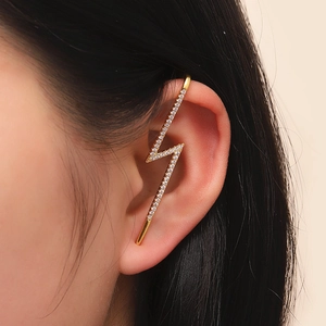 Macro shot of gold lightning bolt ear cuff with sparkling white cubic zirconia
