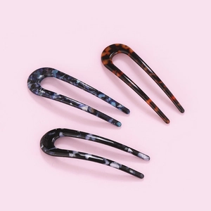 U-shaped hair pins set in tortoise shell and acetate textures for elegant hairstyling