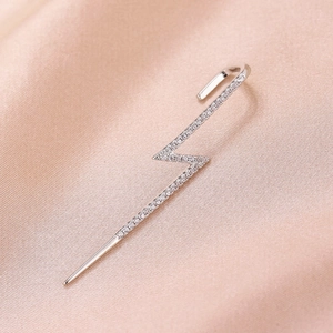 Macro shot of a silver lightning bolt ear cuff featuring sparkling pave-set zircons