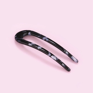 Detailed view of U-shaped hair fork in elegant grey and white marble pattern finish