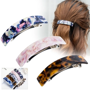 Detailed view of long acetate hair clips in leopard and marble patterns with metal spring