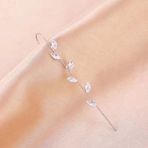 Detailed close-up of leaf-shaped silver ear crawler with sparkling marquise crystals on silk