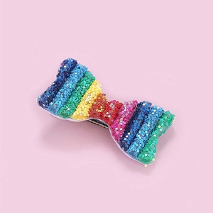 Detaillierte Makroansicht einer Bogenspange mit bunten Regenbogen-Pailletten und Metallclip