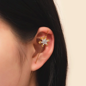 Detail of a golden snowflake ear cuff crawler with sparkling zircon stones