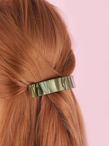 Detail of green marble acetate hair claw clip styled on wavy brunette hair