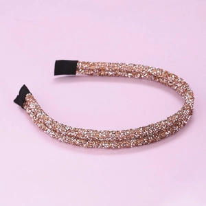 Dettaglio del cerchietto con strass oro champagne e terminali in nastro nero antiscivolo