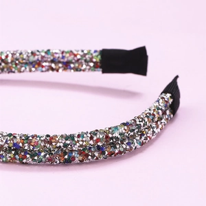 Dettaglio degli strass colorati scintillanti sulla superficie del cerchietto francese a due file