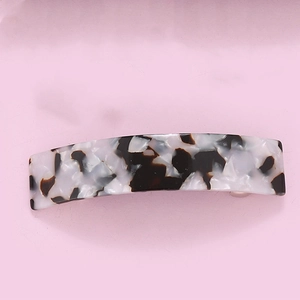Detail view of rectangular acetate hair clip with black and white tortoiseshell pattern