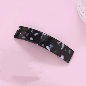 Detail of a rectangular acetate hair clip with purple leopard pattern on pink background