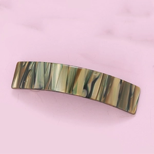 Detailed top view of a marble texture acetate hair claw clip on a pink background