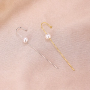 Detail of minimalist gold and silver linear ear cuffs featuring a white round pearl accent