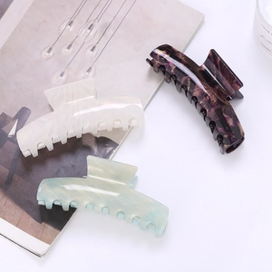 Détail de pinces à cheveux en acétate à motif marbré en crème, violet et bleu