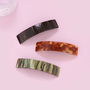 Three-piece acetate hair claw clips with tortoiseshell and leopard patterns on pink background