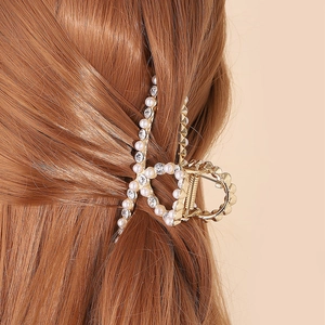 Elegant gold metal hair claw clip with pearls and rhinestones on brunette hair