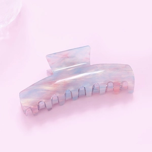 Vue détaillée d'une grande pince à cheveux en acétate marbré rose et bleu effet perlé