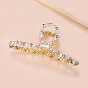 Detailed view of large gold metal shark hair claw with pearls and sparkling rhinestones
