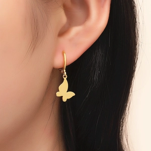 Elegant gold butterfly drop earrings with smooth metallic finish on female model
