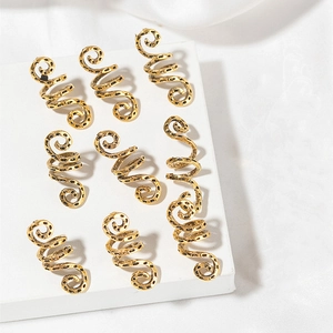 Close-up of eight vintage gold spiral hair rings for dreadlocks on a white display stand
