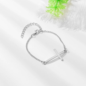 Détail d'un bracelet croix en alliage argenté avec fermoir mousqueton et chaînette