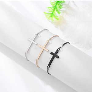 Détails de trois bracelets croix minimalistes en finitions argent, or rose et noir mat