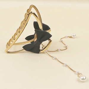 Elegante pinza per capelli in metallo dorato con fiocco nero e nappa di perle