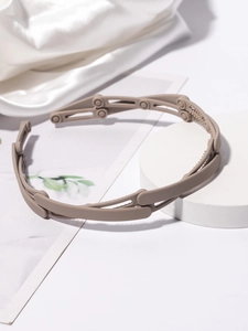 Detail view of foldable brown plastic headband with anti-slip teeth on stone stand