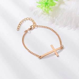 Détail du bracelet croix doré minimaliste avec finition polie et chaîne de réglage fine